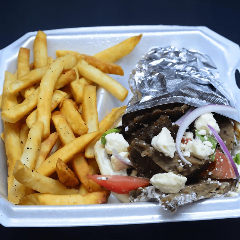 A Habibi Mediterranean Grill gyro with fries, feta, tomatoes, and onions in a styrofoam container.